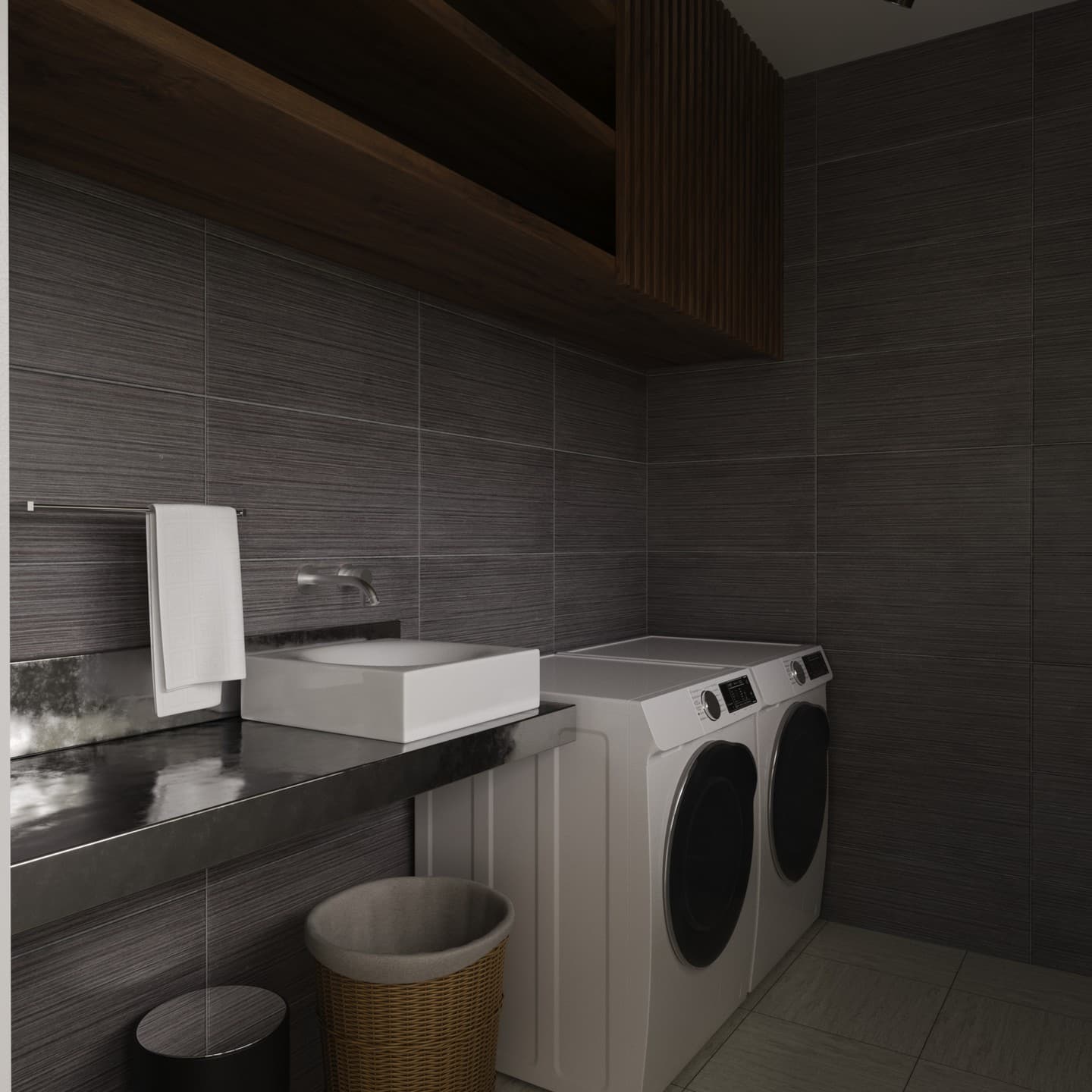 Laundry room in dark linear tile with a stacked washer and dryer, a white basin and walnut shelving